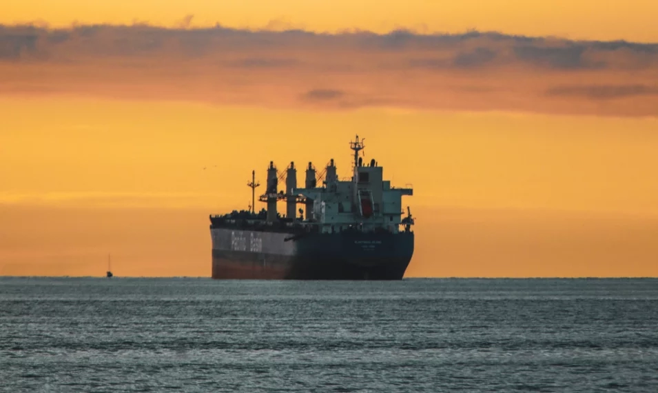 vertical-shot-old-ship-lake-colorful-sky-during-sunset
